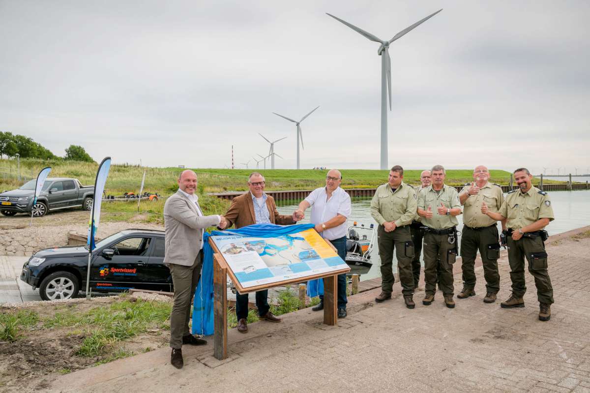 Het infopaneel wordt onthuld door Arend-Jan van der Vlugt (Wethouder gemeente Goeree-Overflakkee), Eric Marteijn (Voorzitter Sportvisserij Zuidwest Nederland) en Hans Bal (Paviljoen Sluishaven).